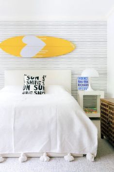 a surfboard mounted on the wall above a bed