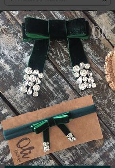 the green ribbon is tied to an envelope with brooches and pearls on it