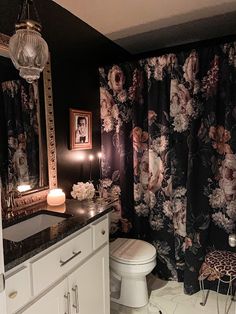 a bathroom with a sink, toilet and shower curtain in it's dark color scheme