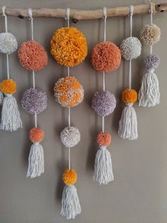 a wall hanging with different colored pom poms