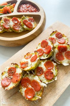 several slices of pizza sitting on top of a cutting board next to a wooden bowl