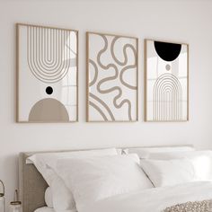 two paintings hang above a bed in a bedroom with white linens and neutral decor