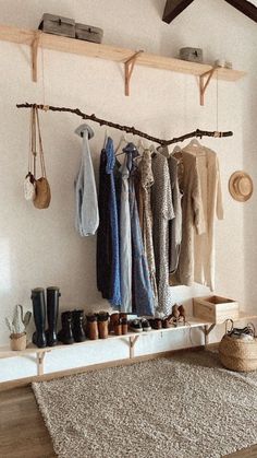 a room filled with lots of clothes hanging on the wall next to a wooden shelf