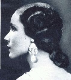 an old black and white photo of a woman with her hair up in a bun