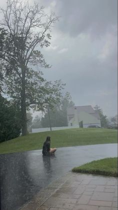 a person sitting in the rain with an umbrella