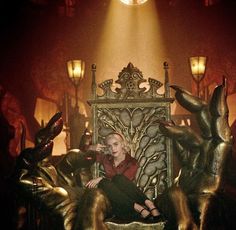 a woman sitting on top of a golden throne