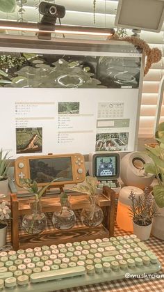 an old computer sitting on top of a table next to potted plants and other items