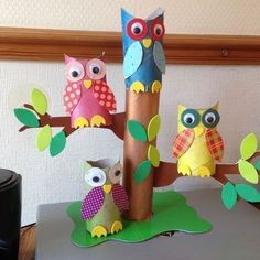 several paper owls sitting on top of a tree