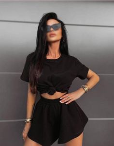 Unveil your style with this sophisticated black outfit. Featuring a chic knotted crop top and ultra-comfortable high-waisted shorts, this ensemble effortlessly combines fashion and comfort. Ideal for every casual outing or laid-back gathering, this versatile set will elevate your wardrobe. Available in various sizes to fit every body type, this must-have outfit ensures you step out in confidence and charm. Casual Black Short Set For Summer, Chic Black Shorts For Loungewear, Chic Black Summer Sets, Black Two-piece Set For Summer, Black Two-piece Crop Top For Summer, Summer Black Two-piece Crop Top, Black Sets For Day Out In Spring, Spring Black Sets For Day Out, Black Short Sleeve Crop Top For Loungewear