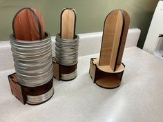 three stacks of wooden spoons sitting on top of a counter next to each other