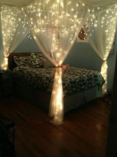 a bed with lights on the headboard and canopy over it