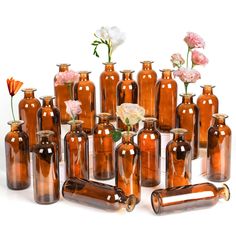 a group of brown glass vases with flowers in the top and bottom one is empty