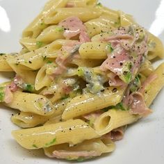 a pasta dish with ham and broccoli on it