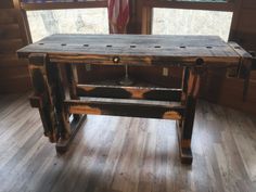 a wooden table sitting on top of a hard wood floor in front of a window