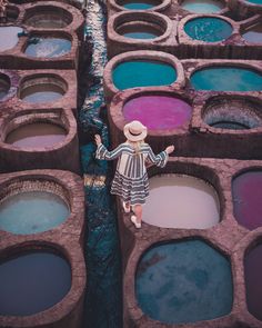 a woman standing in front of rows of blue and pink paint