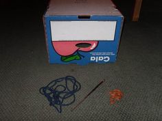 an unopened capa box sitting on the floor next to some cords and other items