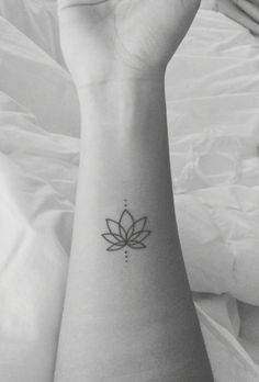 a woman's arm with a lotus tattoo on it