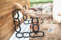 a pair of boots sitting on top of a bench next to a wooden wall and fence