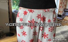 a woman's pants with snowflakes on them and the words wearing warm fuzzy pajamas