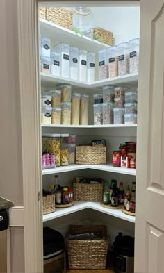 an organized pantry with baskets, food and other items in the shelves on either side of the door