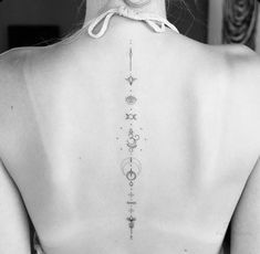 the back of a woman's neck with stars and planets tattoo on her upper back