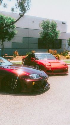 three sports cars parked in front of a building