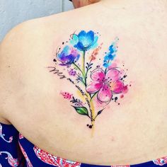 the back of a woman's shoulder with watercolor flowers on it