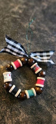 a close up of a beaded bracelet on a rock with a ribbon around it