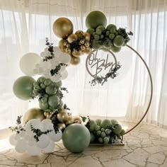 an arrangement of balloons and greenery on a table