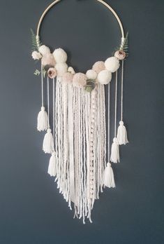 a white macrame with flowers and tassels hanging from it's side