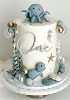 a white cake with blue decorations and an octopus on top