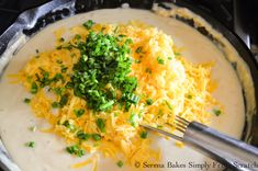 the food is being prepared in the skillet with cheese and chives on top