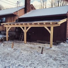 a wooden structure with snow on the ground