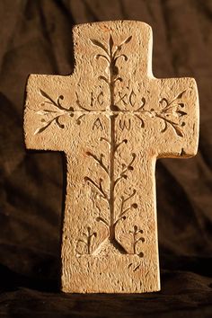 a carved wooden cross sitting on top of a black cloth