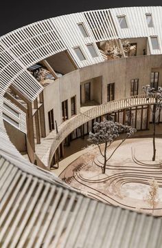 an aerial view of a building with trees in the courtyard