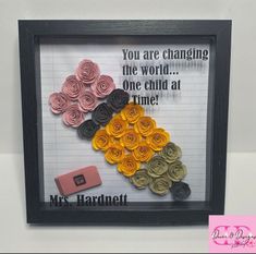 there is a framed picture with paper flowers in the shape of a handmade heart