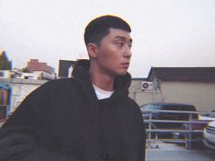 a man standing on top of a roof next to a parking lot filled with cars