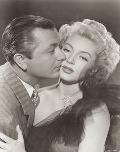 an old black and white photo of a man kissing a woman