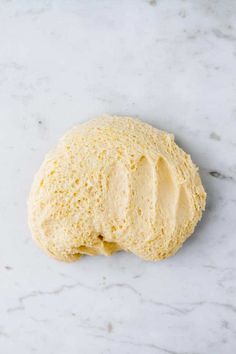 an uncooked piece of bread sitting on top of a white marble countertop