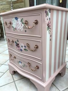 a pink and white dresser with flowers painted on the drawers is shown in this image