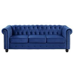 a blue couch with studding on the arms and back, sitting in front of a white background