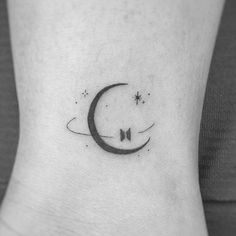 a black and white photo of a crescent tattoo on the ankle