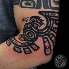 a tattoo on the arm of a man with an eagle and native american symbols painted on it