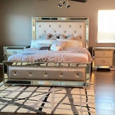 a bedroom with a large bed and mirrored furniture