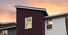 two red and white houses with windows at sunset