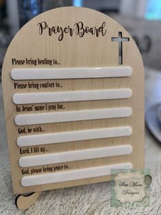 a wooden plaque with the words prayer board written on it and an image of a cross