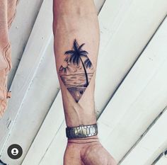 a person's arm with a palm tree and beach scene tattoo on the wrist