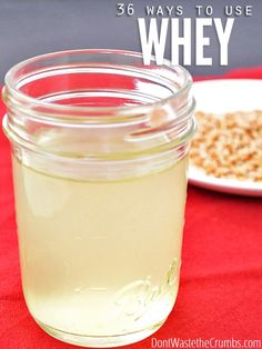 a glass jar filled with liquid sitting on top of a table next to a plate