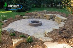 a stone fire pit surrounded by rocks and grass in a yard with the words supertor above it