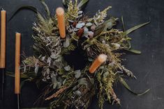 an overhead view of a wreath with candles and greenery on the side, surrounded by other decorations